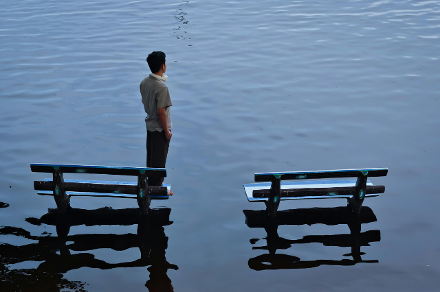 冠水する街に立つ男性