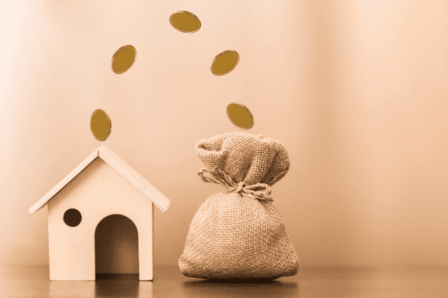 家のミニチュアとお金の袋