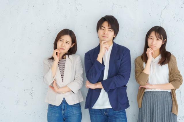 顎に手を当てて悩んでいる男女3人